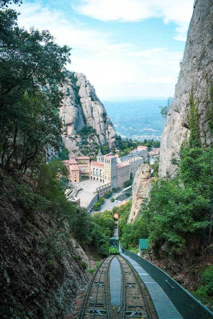 A breathtaking view of Montserrat Monastery nestled between mountains with a cable railway leading up.